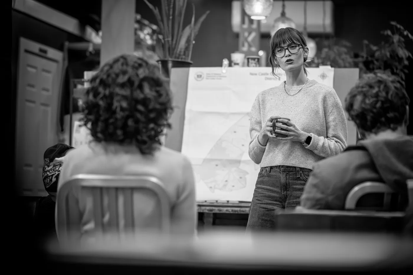 Kira presenting a district map at a community meeting